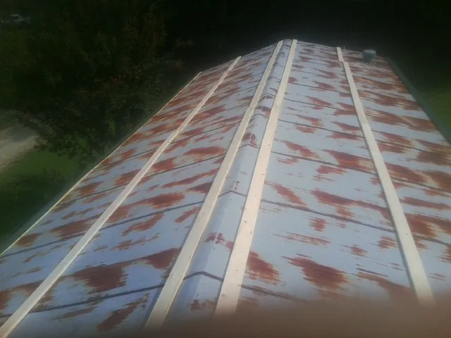 Rusted metal roof panels with new wood purlins before replacement — Storm Damage Roof Repair in Soddy Daisy by Roofing Brothers