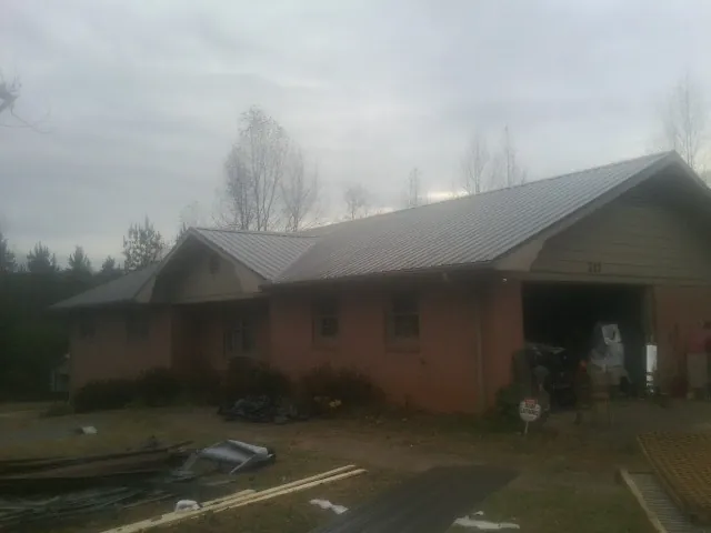 Gray metal roof on a stucco house with an attached garage in Soddy Daisy